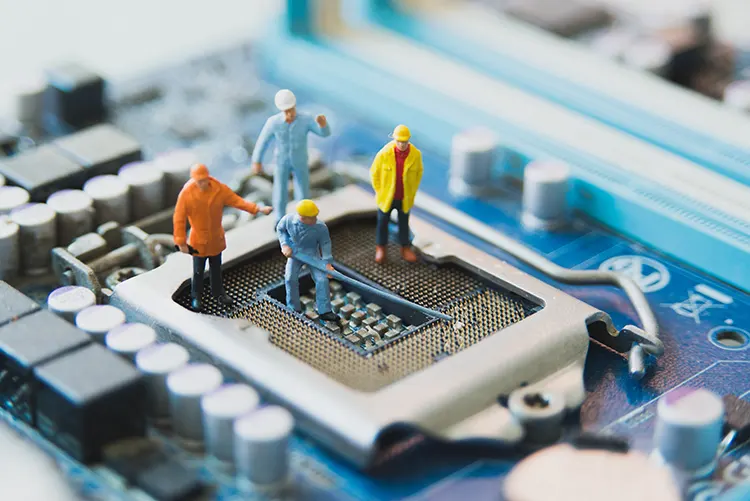 Illustration of firmware development with miniature engineers working on a microcontroller chip
